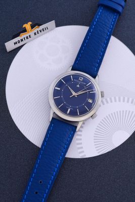 un gros plan d'une montre bleue posée sur une assiette blanche