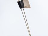un lampadaire noir et doré surmonté d'un abat-jour noir