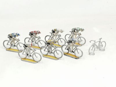 many figurines of people riding bicycles on a white surface