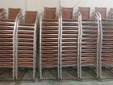 a lot of chairs that are stacked up in a room