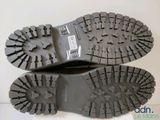 the soles of a pair of black boots on a white surface