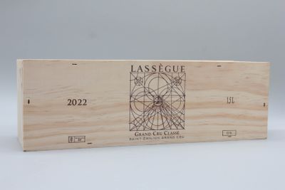 La boîte en bois contient une bouteille de vin et un verre à vin.