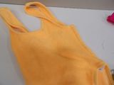 a yellow tank top sitting on a table next to a pair of scissors and a pair of scissors