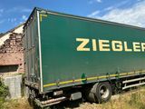 a truck that is sitting in the grass near a building