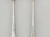 pair of silverware spoons on a white surface with a white background