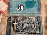 une boîte à outils ouverte posée par terre, contenant un tuyau