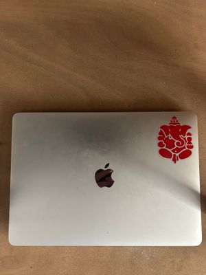 an apple laptop with a red flower sticker on it