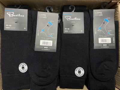 three pairs of men ' s black socks in a cardboard box