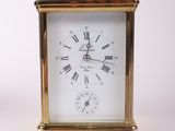 a small gold clock with roman numerals on it