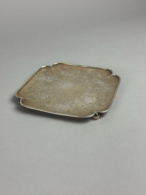 assiette rectangulaire en argent, ornée d'un motif floral sur fond blanc