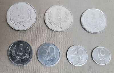 six different coins sitting on top of a table next to each other