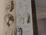 someone is holding a book with a bunch of drawings on it