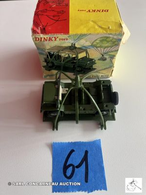 une boîte de petits jouets posée sur une table, à côté d'une feuille de papier