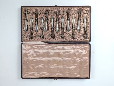 cinq cuillères en argent dans un coffret posé sur une table