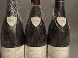 three bottles of wine wrapped in plastic sitting on a table