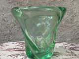 un vase en verre vert posé sur une table recouverte d'une nappe rouge et blanche
