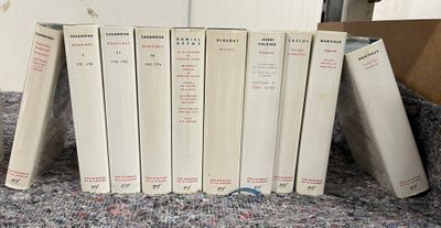 Plusieurs livres sont empilés les uns sur les autres sur un tapis
