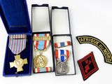 three medals and a medal in a blue case on a white surface