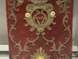 a red and gold plaque on display in a glass case