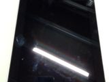une tablette noire posée sur une table blanche