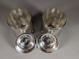 pair of silverplated cups with lids on a table