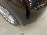 a man standing in front of a black car