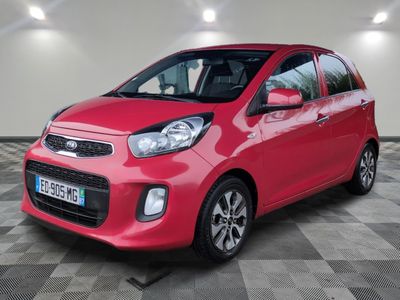 Une voiture rouge est garée dans un garage dont le sol est en damier.
