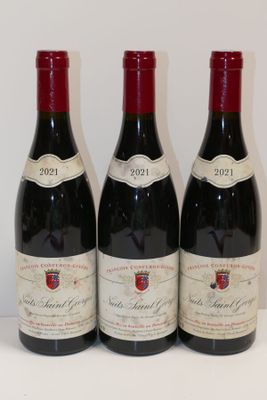 trois bouteilles de vin rouge sont alignées sur une table