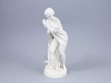 une figurine blanche représentant une femme tenant une fleur