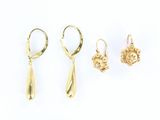 trois paires de boucles d'oreilles en or posées sur une surface blanche, sur fond blanc