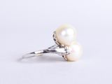 a close up of a pearl ring on a white surface