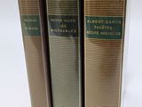 trois livres superposés sur une surface blanche