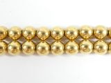 a close up of a row of gold beads on a white surface