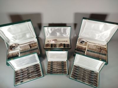 trois boîtes ouvertes contenant de l'argenterie, posées sur une table
