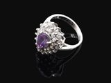 une bague en améthorate et diamant posée sur une surface noire