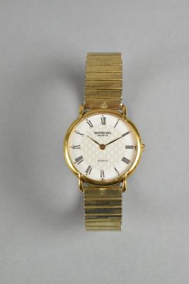 a close up of a gold wrist watch with roman numerals