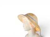 marble bust of a woman wearing a hat and a yellow and white striped dress