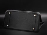 a black leather wallet with gold studding on a black background