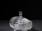 an image of a glass bottle on a table with a black background