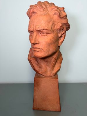 a close up of a clay bust of a man on a table