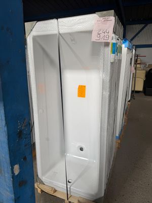 de nombreuses toilettes dans un entrepôt, avec une étiquette de prix accrochée au mur
