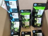 plusieurs paquets de cartouches d'encre dans une boîte en carton posée sur une table