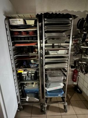many trays of food on a metal rack in the kitchen