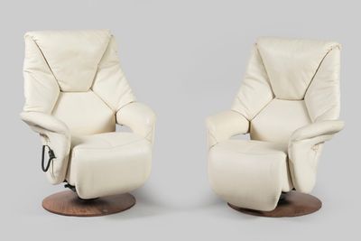 pair of cream leather recliners with wooden base and foot rest