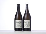 two bottles of wine sitting on top of a table next to each other