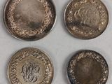 four different types of coins are shown on a white surface