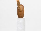 a wooden sculpture of an apple on a pedestal with a white background