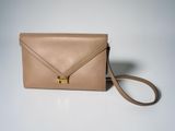 a beige leather envelope bag with a gold metal clasp