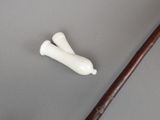 a small white object on the table next to a wooden stick