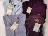 trois pulls pour homme, encore étiquetés, posés sur une table